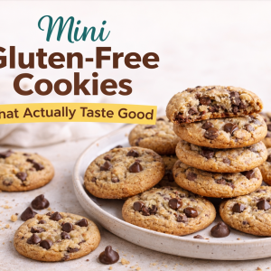 Mini gluten-free chocolate chip cookies on a plate with one cookie broken open to show a chewy center